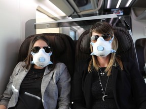 Passengers wear masks on a train from Rome to Milan on February 25, 2020 in Milan, Italy.