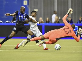 Impact's Rod Fanni (7) challenges DeJuan Jones (24) of the New England Revolution as the ball is shot toward goalkeeper Clement Diop at Olympic Stadium on Saturday, Feb. 29, 2020, in Montreal.