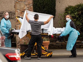 Health-care workers transport a patient on a stretcher into an ambulance at Life Care Center of Kirkland in Kirkland, Wash. Dozens of staff and residents at Life Care Center of Kirkland are reportedly exhibiting coronavirus-like symptoms, with two confirmed cases associated with the nursing facility reported so far.