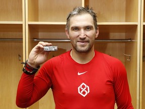 Capitals' Alex Ovechkin poses for a photo with the puck scored for his 700th NHL goal against the Devils at Prudential Center on Saturday, Feb. 22, 2020, in Newark, N.J.