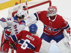 Canadiens goalie Carey Price keeps a close eye on the puck with teammate Shea Weber and Rangers' Filip Chytil battling in front of the net Thursday night at the Bell Centre. Expect Price to get the start for Montreal on Saturday night.