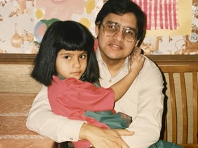 A young Fariha Naqvi-Mohamed sits on her father's lap in the kitchen of their home in Dollard-des-Ormeaux in 1989.