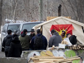 A crowd gathers after hearing the news of a CP Rail injunction as the Mohawks of Kahnawake continue their blockade Feb. 25, 2020.