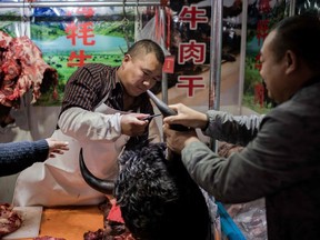 This picture taken on Jan. 15, 2020, shows a butcher selling yak meat at a market in Beijing. The World Health Organization (WHO) said on Jan. 20 it believed an animal source was the "primary source" of the coronavirus outbreak, and authorities in the central Chinese city of Wuhan identified a seafood market in their city as the centre of the epidemic, but China has since confirmed that there was evidence the virus is now passing from person to person, without any contact with the now-closed market.