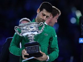 Serbia's Novak Djokovic holds the Norman Brookes Challenge Cup trophy after beating Austria's Dominic Thiem in their men's singles final match on day fourteen of the Australian Open tennis tournament in Melbourne on February 3, 2020.