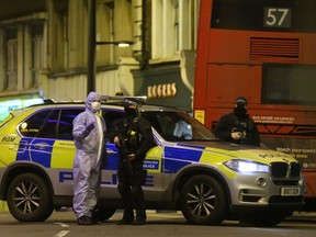 A police forensic officer speaks with a police officer as he works on Streatham High Road in south London on February 2, 2020, after a man is shot dead by police following reports of people being stabbed in the street. - British police on Sunday said they had shot a man in south London, after at least two people were stabbed in a suspected "terrorist-related" incident.