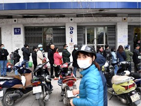 People line up to buy protective face masks amid concerns of the novel coronavirus outbreak that originated in central China, outside a shop in Hanoi on February 10, 2020.