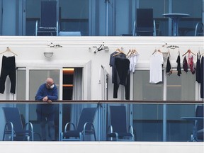 A passenger is seen on a balcony of the Diamond Princess cruise ship, with about 3,600 people quarantined onboard because of fears of the new coronavirus, at the Daikoku Pier Cruise Terminal in Yokohama port on Sunday, Feb. 14, 2020. The ship has become the single largest cluster of cases outside China, with at least 218 testing positive for COVID-19 and taken to medical facilities.