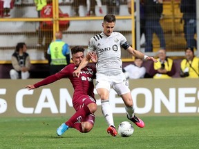 Deportivo Saprissa player Manfred Ugalde, left, battles Impact's Jukka Raitala for the ball during their during their CONCACAF Champions League match at Ricardo Saprissa Stadium in San José Wednesday night.