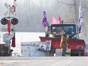 A First Nations protester walk in front of a snow plow blade that has signatures from the Wet'suwet'en hereditary chiefs as part of a train blockade in Tyendinaga, near Belleville, Ontario, Canada on February 21, 2020.