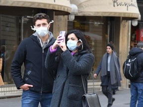 Tourists with protective mask visit Florence on Feb. 25. On Wednesday, Westmount High School postponed an 11-day trip to Florence, Venice and Athens for 51 of its students with only 24 hours’ notice.