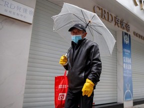 A man wears a face mask in a deserted shopping street in Jiujiang, Jiangxi province, China, as the country is hit by an outbreak of the novel coronavirus, on Sunday, Feb. 2, 2020.