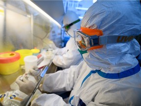 Workers in protective suits conduct RNA tests on specimens inside a laboratory at a centre for disease control and prevention, as the country is hit by an outbreak of the novel coronavirus, in Taiyuan, Shanxi province, China, on Feb. 14, 2020.