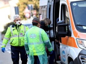 A woman is taken into an ambulance amid a coronavirus outbreak in northern Italy, in Casalpusterlengo, on Saturday, Feb. 22, 2020.