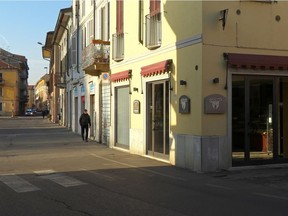 People walk down an empty street in the village of Codogno after officials told residents to stay home and suspend public activities as 14 cases of coronavirus are confirmed in northern Italy, in this still image taken from video in the province of Lodi, Italy, on Friday, Feb. 21, 2020.