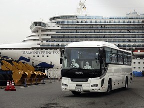 A bus leaves a port where the quarantined Diamond Princess is docked Saturday, Feb. 15, 2020, in Yokohama, near Tokyo. (AP Photo/Jae C. Hong)