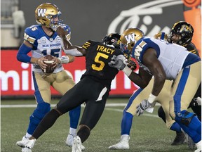 Tiger-Cats defensive end Adrian Tracy charges at Blue Bombers quarterback Matt Nichols(15) for the sack last season.