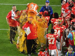 Kansas City Chiefs head coach Andy Reid is dunked with Gatorade by his players Jordan Lucas (24) and Cameron Erving (75) in the fourth quarter in Super Bowl LIV against the San Francisco 49ers at Hard Rock Stadium.