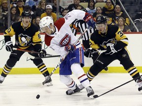 Canadiens' Jake Evans handles the puck ahead of Penguins' Juuso Riikola (50) and Sam Lafferty (37) during the first period at PPG PAINTS Arena on Friday, Feb. 14, 2020, in Pittsburgh.