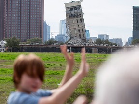 Randy Gibson takes a photo of his son Andrew, 11, in front of the 'Leaning Tower of Dallas' on Monday, Feb. 17, 2020 in Dallas. A demolition of the former Affiliated Computer Services tower on Sunday morning left the central core behind.
