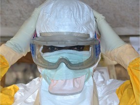 A Guinean health worker wears a protective suit at an Ebola treatment centre in Conakry in December, 2014. With the World Health Organization struggling to contain coronavirus, are the rules being applied properly and prudently?