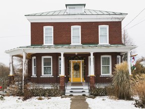 This unusual architectural design — a boxy two-storey residence with a flattened pyramid-style roof design — is known as an American Foursquare house.