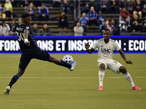 Impact midfielder Romell Quioto (30) plays the ball and New England Revolution forward Cristian Penilla defends at Olympic Stadium on Saturday, Feb. 29, 2020, in Montreal.