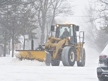 A front-end loader clears a snowed-in street as a snow storm hits in Quebec City, Friday, February 7, 2020.