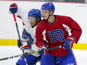Laval Rocket forward Nikita Jevpalovs, right, battles for position with defenceman Nathanael Halbert during practice in Laval on March 3, 2020.