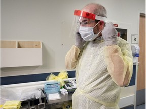 Claude Menard gowns up during a media tour at a new COVID-19 testing centre located in the old Hotel Dieu Hospital in Montreal, on Tuesday, March 10, 2020.