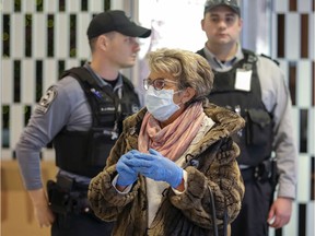 Graciela Vogel wears a mask and gloves while waiting for a friend to arrive at Trudeau Airport in Montreal Monday March 16, 2020. (John Mahoney / MONTREAL GAZETTE) ORG XMIT: 64106 - 4683