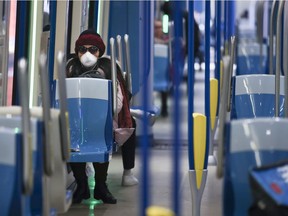 MONTREAL, QUE.: MARCH 16, 2020 -- A woman wears a mask while sitting in a near-empty Metro car leaving the Angrignon station in Montreal Monday March 16, 2020. (John Mahoney / MONTREAL GAZETTE) ORG XMIT: 64104 - 0560