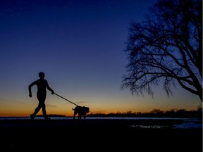 MONTREAL, QUE.: MARCH 15, 2020 -- A woman runs with her dog at sunset on the waterfront in the Lachine borough of Montreal Sunday March 15, 2020. (John Mahoney / MONTREAL GAZETTE) ORG XMIT: 64099 - 4427
