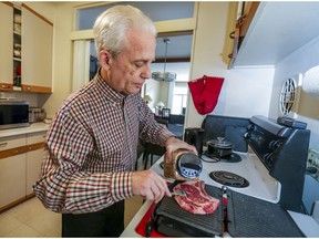 Bernie Green, a 75-year-old widower, grills a steak at his home in Montreal West on March 19, 2020.