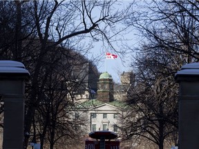 The McGill flag flies over the Arts Building as seen through the Roddick Gates at McGill University.