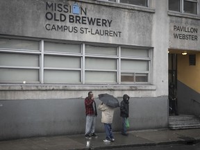 People of the Old Brewery Mission stand outside on March 20, 2020.
