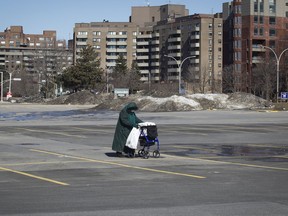 95-year-old Carmen Larivière crosses a nearly empty parking lot at the Cavendish Mall in the Côte-Saint-Luc area of Montreal Saturday, March 21, 2020 after buying some supplies. She lives alone in Côte-Saint-Luc. There are six confirmed cases of COVID-19 connected to people or places in Côte Saint-Luc and the mayor would like the health department to consider quarantining the city. (John Kenney / MONTREAL GAZETTE) ORG XMIT: 64136
