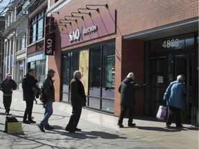 People line-up outside an SAQ location in the Westmount area of Montreal Saturday, March 21, 2020.