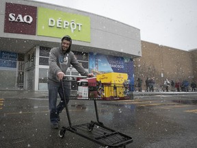 Jonathan Silla walks out of the SAQ Depot at Marché Central after doing some shopping on March 23, 2020. The SAQs will be allowed to stay open in Quebec as an essential service.