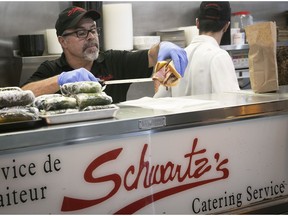 Schwartz's general manager Frank Silva wraps up a smoked-meat sandwich for takeout at Montreal restaurant on March 24, 2020.