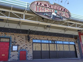 Sheets of plywood cover the windows at McKibbin's Irish Pub in Pointe-Claire, Friday, March 27, 2020 after recent vandalism.