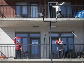 Seniors Madeleine Riel, top right, Lise Charette, left, and Nicole Dubois, participates in an outdoor Zumba class from the balcony of a seniors residence in Blainville on Friday March 27, 2020.