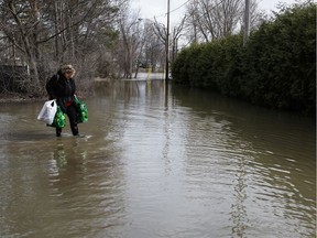 France Godin walks towards her house on a flooded Laval street in 2019.