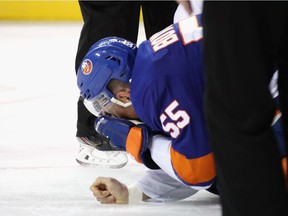 New York Islanders defenceman Johnny Boychuk covers his face after being struck by the skate of Canadiens forward Artturi Lehkonen during NHL game at the Barclays Center in Brooklyn, N.Y., on March 3, 2020.