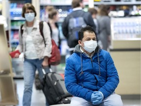 People cover up with masks and gloves at Pierre Elliott Trudeau Airport in Montreal, on Wednesday, March 11, 2020. (Allen McInnis / MONTREAL GAZETTE) ORG XMIT: 64084