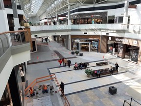 Shoppers and a renovation work crew are shown at Fairview shopping mall in Pointe-Claire at lunchtime on Monday, March 16, 2020. Peter McCabe/Montreal Gazette
