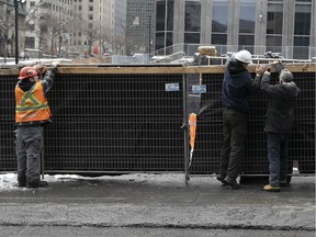 Workers shut down a construction site at René-Lévesque Blvd. and Bleury St. on March 24, 2020 as part of Quebec's lockdown against COVID-19.
