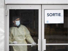 A Montreal health-care worker mans the doors at a COVID-19 test centre.