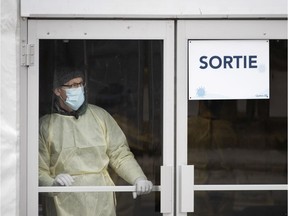 A health care worker mans the doors at the Covid-19 test centre as the city deals with the coronavirus crisis in Montreal, on Thursday, March 26, 2020. (Allen McInnis / MONTREAL GAZETTE) ORG XMIT: 64