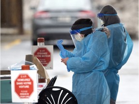Health care workers prepare to carry out drive-through tests for COVID-19 at an installation at the Cavendish Mall in Côte-St-Luc as the city deals with the coronavirus pandemic on Monday, March 30, 2020.